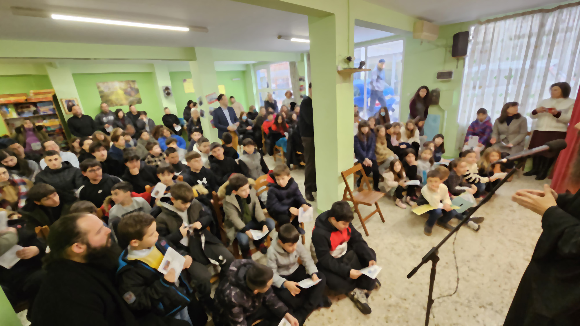Παιδιά και γονείς συγκεντρωμένοι στο Νεανικό Κέντρο για γιορταστική εκδήλωση